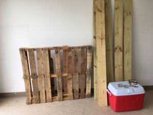 Plastic cooler with wooden planks next to it