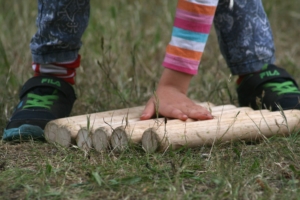 Little girls hand about to pick up a wooden baton