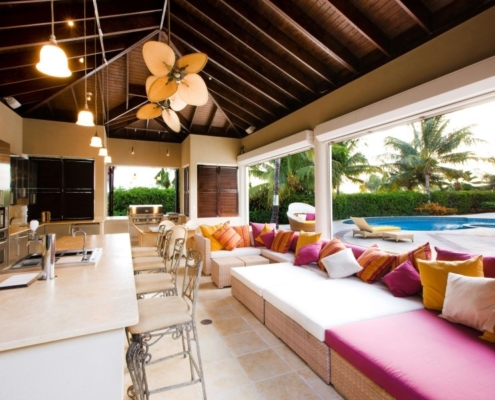 outdoor kitchen with overhang and ceiling fans in tropical setting