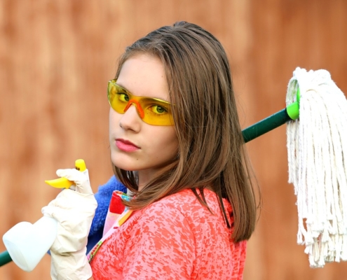 girl holding cleaning products clean
