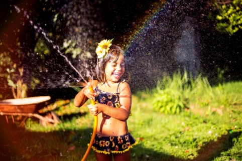 Little girl playing with a sprinkler